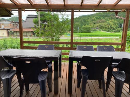 dos mesas y sillas bajo una pérgola en una cubierta en 無鹿リゾート en Kokuryō