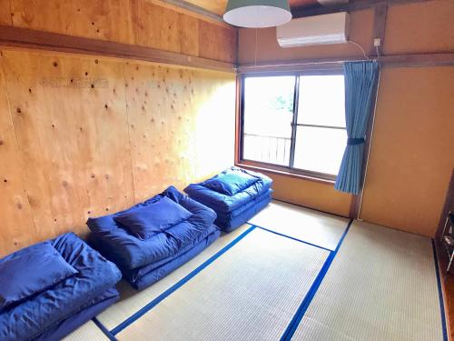 Habitación con 2 pufs y ventana en 青とサイダー, en Oshima