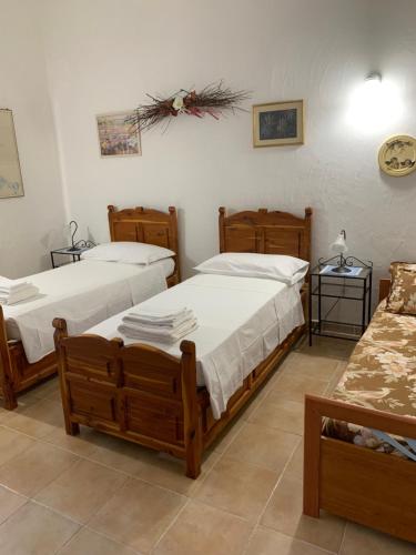 1 dormitorio con 2 camas y sofá en casa del ginepro Lu sali, en Casagliana