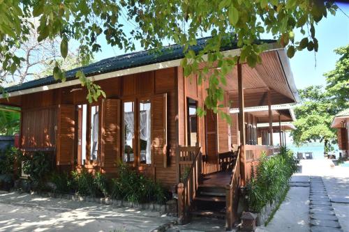 a wooden house with wooden shuttered windows at Bobocha Siladen Boutique Resort in Bunaken