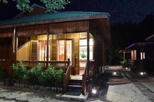 a small house with a porch at night at Bobocha Siladen Boutique Resort in Bunaken