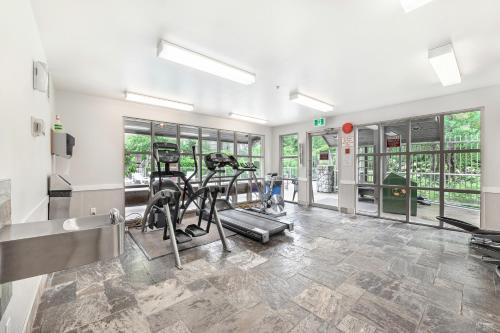 a gym with two treadmills and elliptical machines at The Best Top Floor Ski-in/Ski-out at the Aspens in Whistler