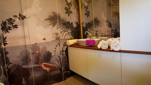 a bathroom with a sink and a flamingo wallpaper at CUBE apartments in Vir