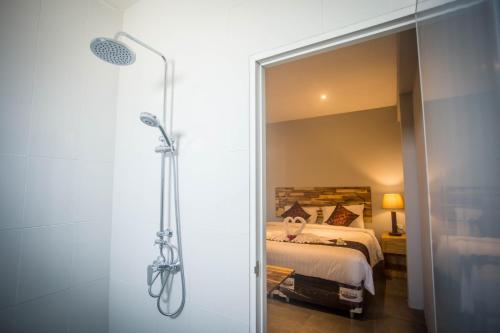 a bathroom with a shower and a bed in a room at @HOsTEL PHANGAN in Baan Tai