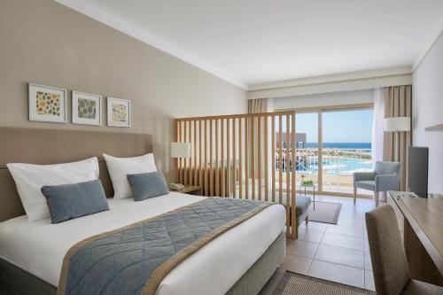 ein Hotelzimmer mit einem Bett und einem Balkon in der Unterkunft Jaz Maraya Resort in Bucht von Coraya