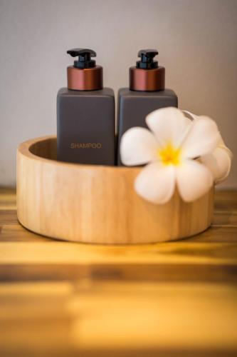 two bottles of shiraz on a wooden holder with a flower at @HOsTEL PHANGAN in Baan Tai