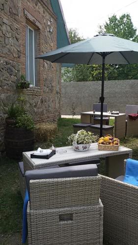 a picnic table with an umbrella and a table with at Nino's House in Tsinandali