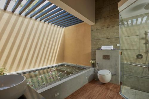 a bathroom with a tub with a toilet and a sink at The Villas, Wadduwa in Wadduwa
