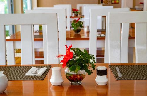 a table with a vase with a red flower in it at Aquarius On The Beach in Nadi