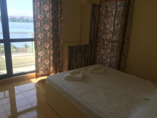 a bedroom with a bed and a large window at Хотел Paradise in Tsarevo