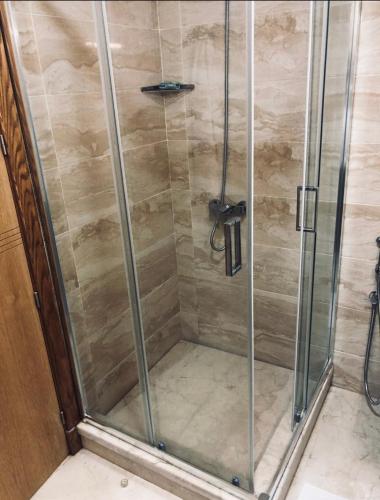 a shower with a glass door in a bathroom at Haut standing beach apartment in Tangier