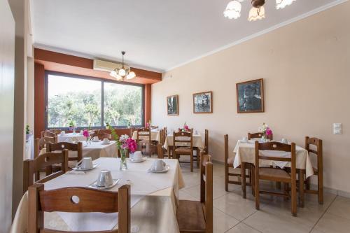 a dining room with tables and chairs and a window at Glaros Hotel in Palaiochóra