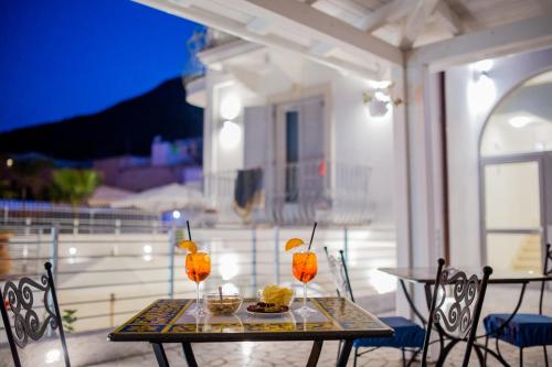 un tavolo con bevande e cibo su un patio di Odysseus Hotel a Città di Lipari