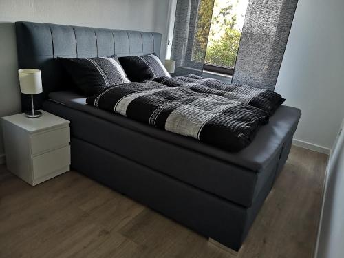 a black bed with pillows on it in a room at Ferienwohnung "Am Kreuzfelsen" in Bestwig