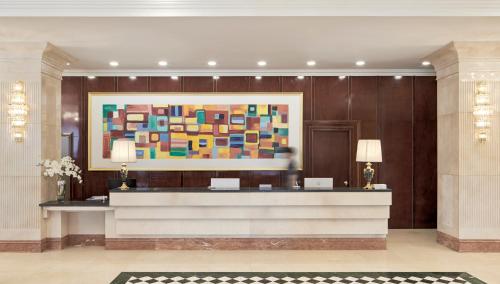 a hotel lobby with a large painting on the wall at GoldOne Hotel & Suites in Seogwipo