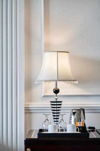 a lamp on top of a table with a tea kettle at GoldOne Hotel & Suites in Seogwipo
