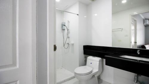 a white bathroom with a shower and a toilet at The Ocean Pearl in Pattaya South
