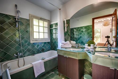 a bathroom with two sinks and a bath tub and a tubermott at Les Bastidieres - Cap Brun in Toulon
