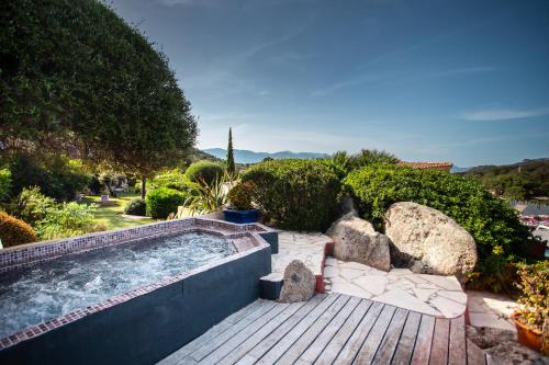 a swimming pool in a garden with rocks at Le Roc E Fiori Hotel - Teritoria in Porto-Vecchio
