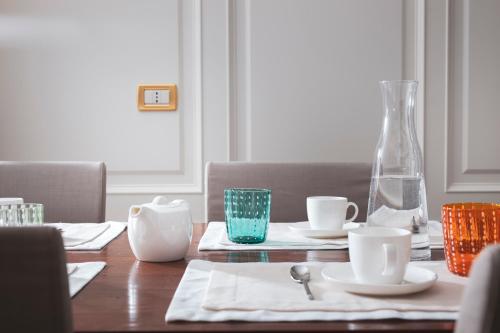a wooden table with two cups and a vase on it at Residenza Ducato in Venice