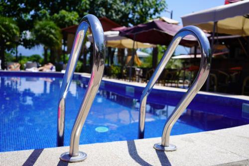 un par de escaleras de metal que conducen a una piscina en Ponto Hotel, en Kobuleti