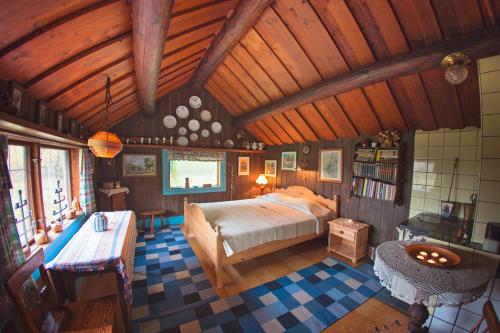 a bedroom with a large bed and a wooden ceiling at Egen stuga med delat badrum in Norrtälje