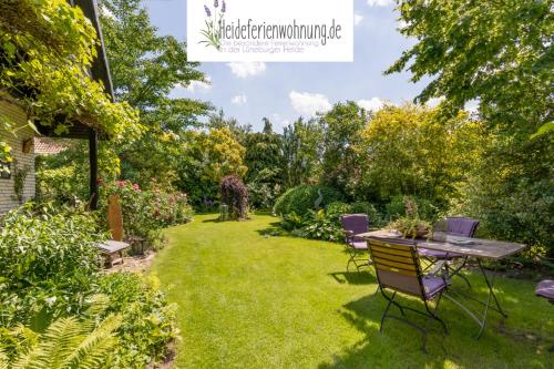 a garden with a table and chairs in the grass at heideferienwohnung in Walsrode