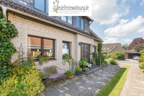 a brick house with a bench in front of it at heideferienwohnung in Walsrode