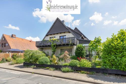 a house with a balcony on top of it at heideferienwohnung in Walsrode