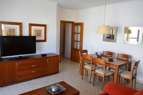 a living room with a television and a table with chairs at AV Andalucía - Tarifa - Parking incluido in Tarifa