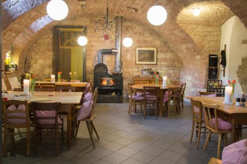 a restaurant with wooden tables and chairs and a fireplace at Fuxbau in Neustadt an der Weinstraße