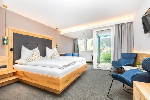 Hotel Forellenhof في فلاخاو: غرفة فندق بسرير وكراسي زرقاء