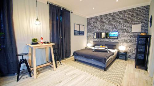 sypialnia z łóżkiem i ceglaną ścianą w obiekcie Frank-Kiss Apartments w mieście Rijeka