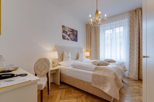 a bedroom with a bed and a desk and a window at Boutique Hotel Goldenes Lamm Villach in Villach