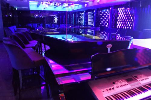 a room with a bar with chairs and a piano at Merit Grand Mosta Spa Hotel & Casino in Svilengrad