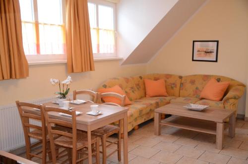 a living room with a couch and a table at Ferienresidenz Am Strom in Warnemünde