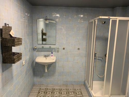 a blue tiled bathroom with a sink and a shower at Kobuleti VILLA SKAZOCNI DVORIK VIP in K'obulet'i