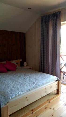 a bedroom with a wooden bed with a window at Brīvdienu māja INESE in Bernāti