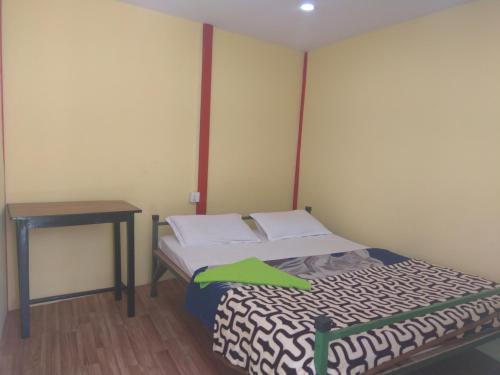 a small bedroom with a bed and a table at Family Peace House, Kathmandu in Kathmandu
