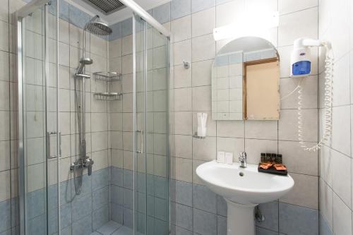 a bathroom with a sink and a shower at Glaros Hotel in Palaiochóra