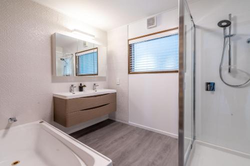 a bathroom with a tub and a sink and a shower at Wanaka Lake walk 2 town, Lake & Mount View, townhouse in Wanaka