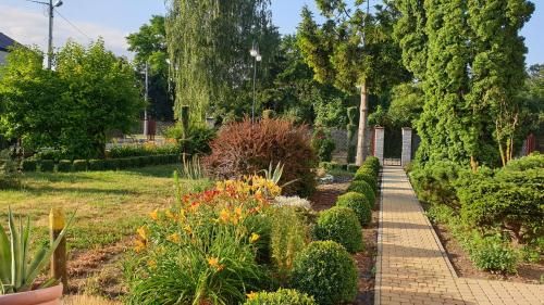 um jardim com um passadiço de tijolos e arbustos em Agroturystyka u Joli em Pacanów