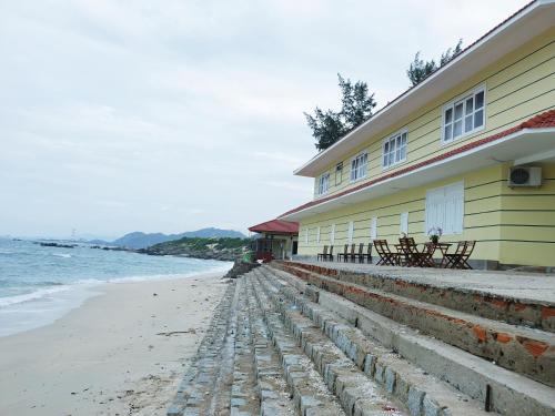 a building on the beach next to the ocean at Mũi Dinh Hotel in Phan Rang