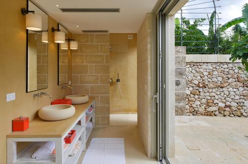 un bagno con due lavandini e una cabina doccia di Masseria Trapana a Lecce