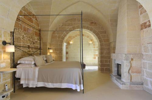 a bedroom with a bed and a fireplace at Masseria Trapana in Lecce