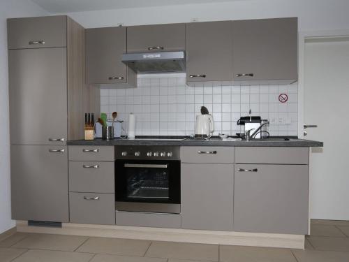 a kitchen with white cabinets and an oven in it at Ferienwohnung Rheingeschaut in Bad Bellingen