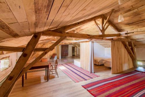 a room with a wooden ceiling with a table and a bed at Château de La Combe in Puyrenier