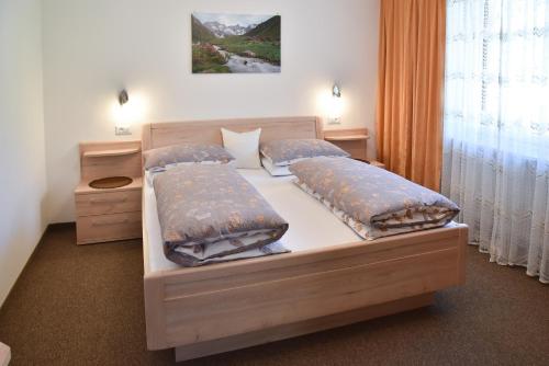 a bedroom with a bed with two pillows on it at Ferienwohnungen Burgwies in San Martino
