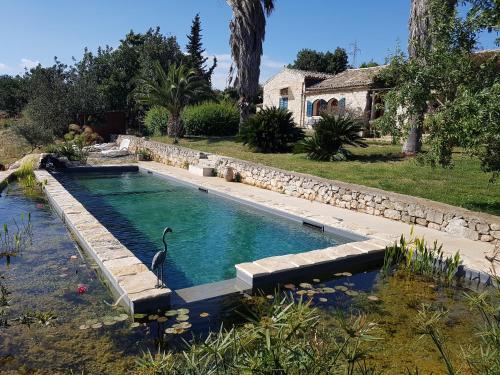 a swimming pool with a swan in the water at Case Brizza in Casale Zappulla