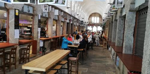 a group of people sitting at tables in a restaurant at Luxury apartment-free parking in Santiago de Compostela